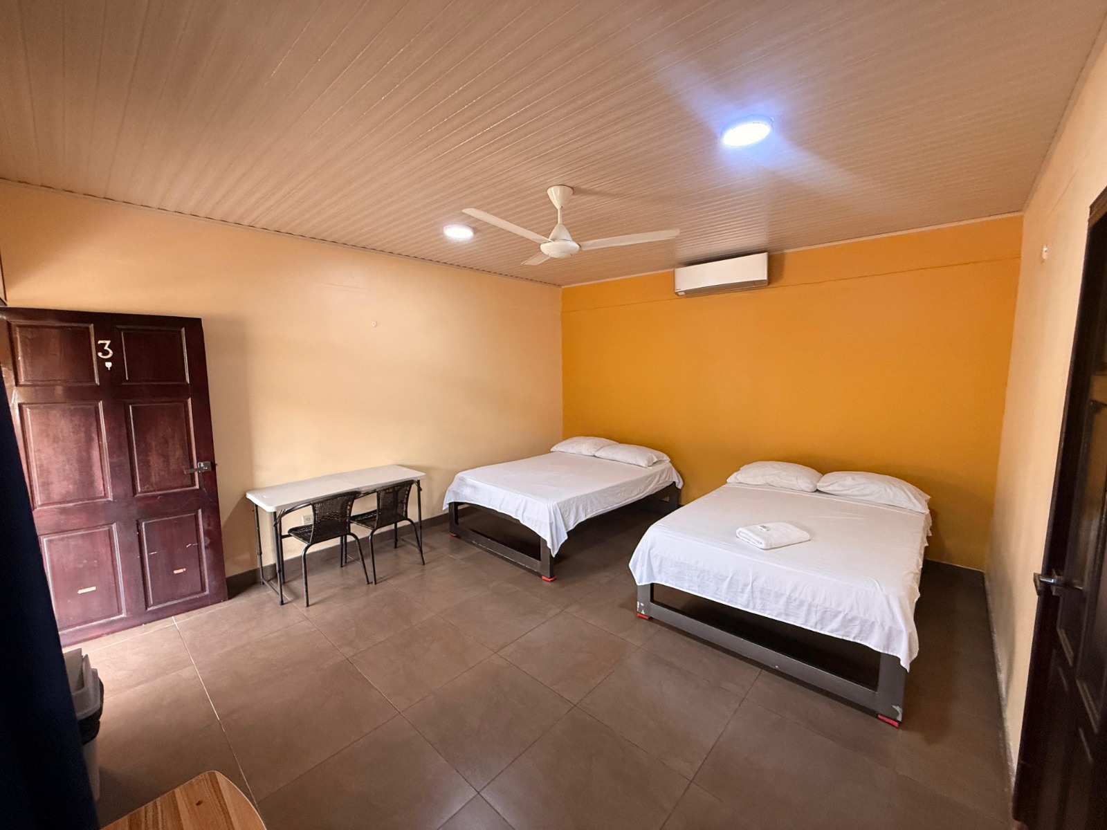 Habitación con dos camas matrimoniales y aire acondicionado