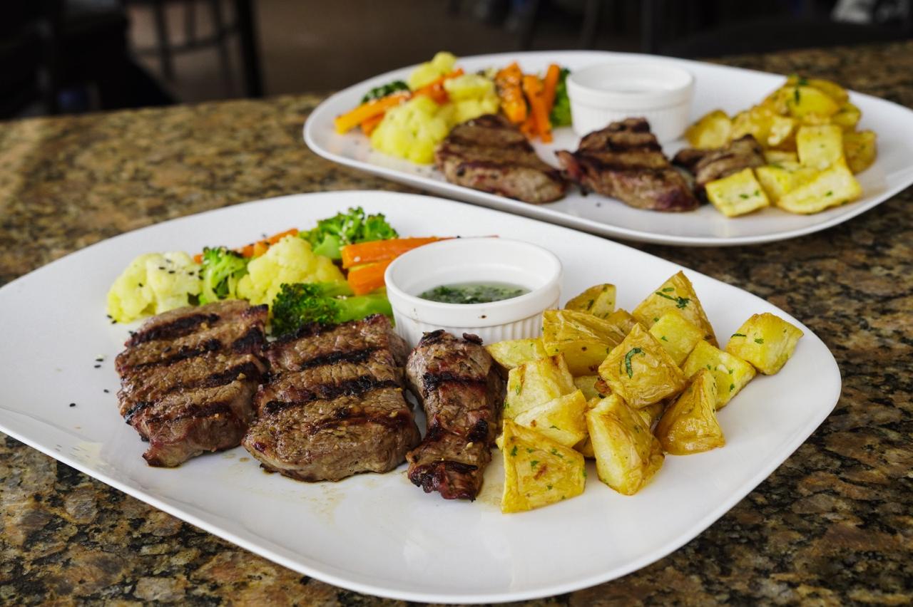 Cortes de carne a la parrilla con papas y chimichurri